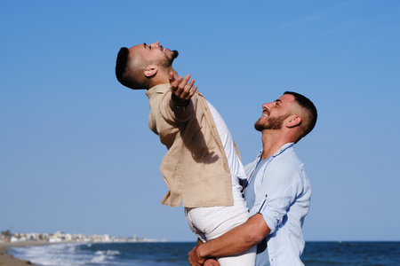 Happy male couple enjoying at the beach together. Lgbt concept.の写真素材