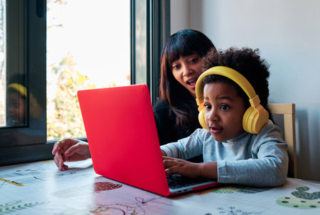 Mother and son playing with a laptop at homeの写真素材