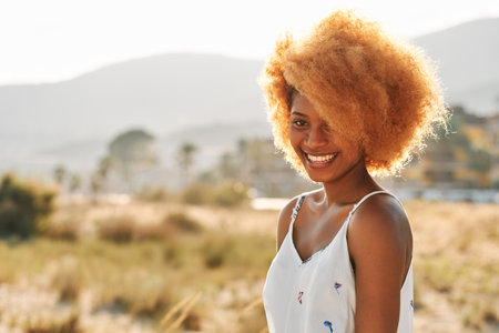 Smiley woman with afro hairstyle outdoorsの写真素材