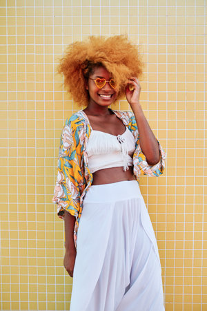 Afro woman posing with white clothes and heart shape sunglassesの写真素材