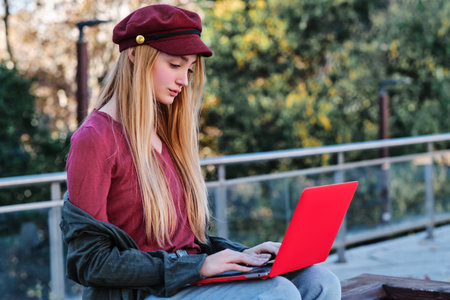 Serious blonde woman working with laptop outdoorsの写真素材