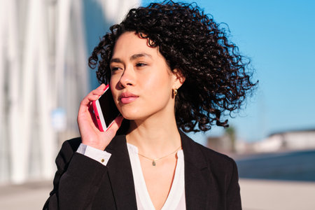 Businesswoman talking to the mobile outdoors on a windy day
