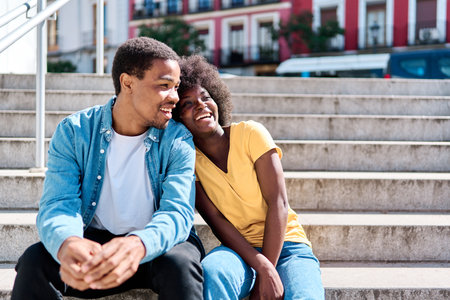 African couple sitting together on stairs in the streetの写真素材