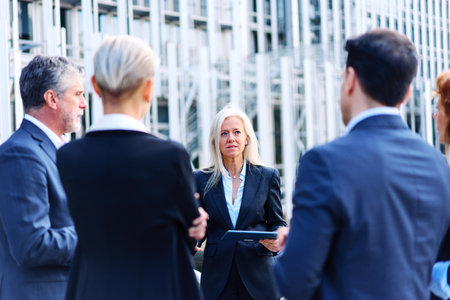 Group of business people talking outside a financial buildingの写真素材