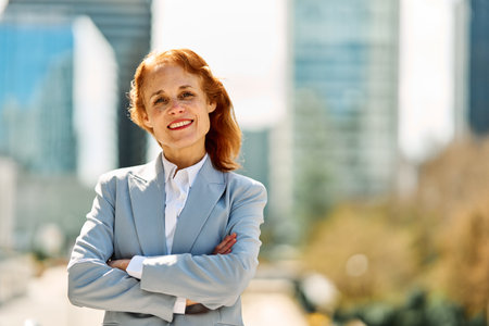 Adult businesswoman smiling proud while standing outdoorsの写真素材
