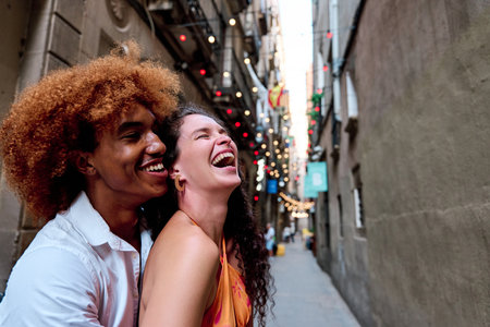 multiethnic couple of tourists laughing in Gothic Quarter, Barcelona, Spain