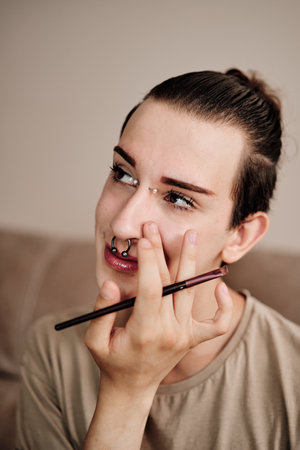 Gay man applying make up at homeの写真素材