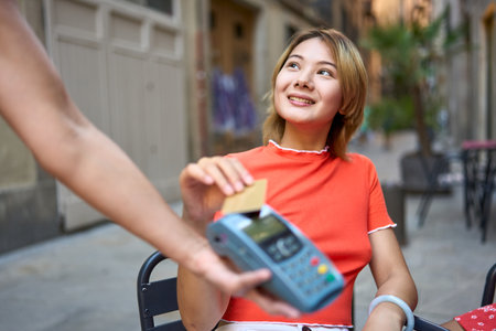 Chinese girl using the credit card to pay in a cafeteriaの写真素材