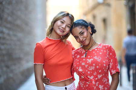 Lesbian couple standing embraced by the backの写真素材