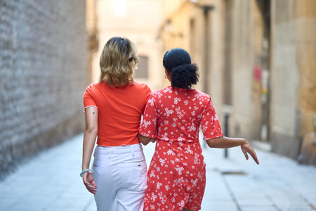 Lesbian couple walking holding hands in the cityの写真素材