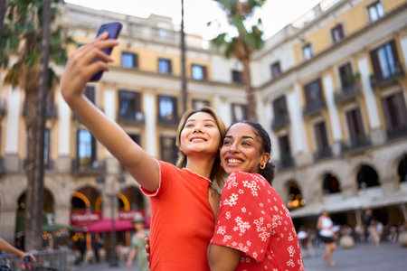 Lesbian couple taking a selfie in a squareの写真素材