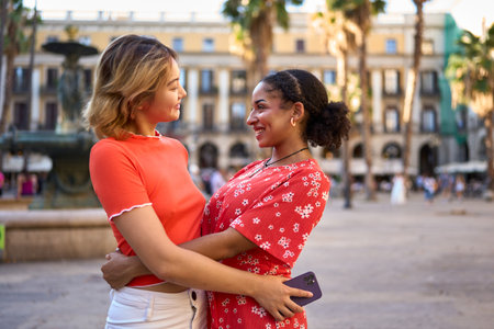 Lesbian couple embracing in a square downtownの写真素材
