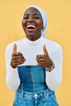 Happy african muslim woman gesturing agreement raising a thumb upの写真素材