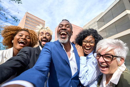 Happy african businessman taking a selfie laughing with multi-ethnic colleaguesの写真素材