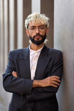 Modern businessman standing with arms crossed and serious lookの写真素材