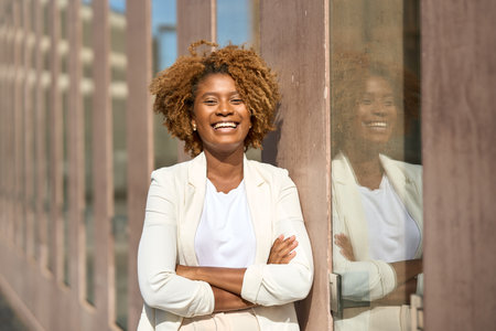 Happy african businesswoman smiling at camera in the cityの写真素材