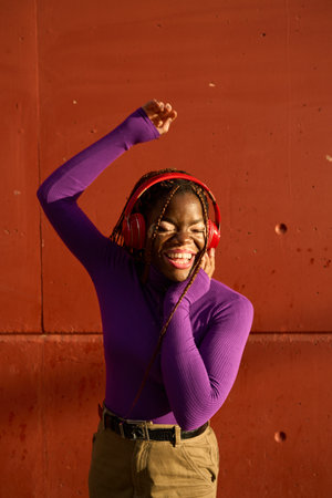Radiant Young Woman Dancing with Red Headphonesの写真素材