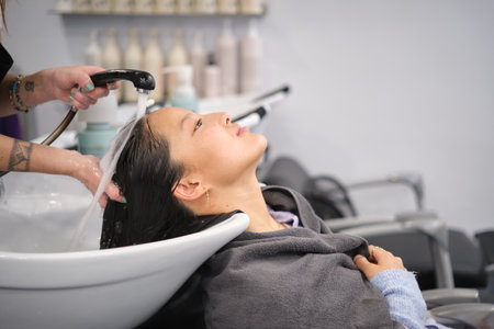 Woman leaning during a pleasurable head wash at hair salonの写真素材