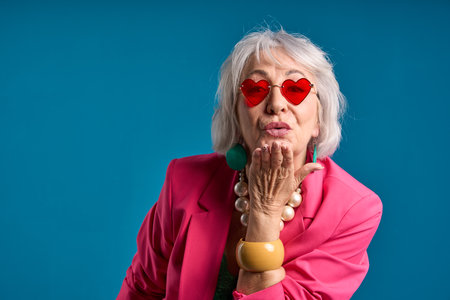 Senior Lady with Heart-Shaped Sunglasses Sending a Kiss