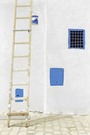 Painting a wall in a sunny day in Tunisia.の写真素材