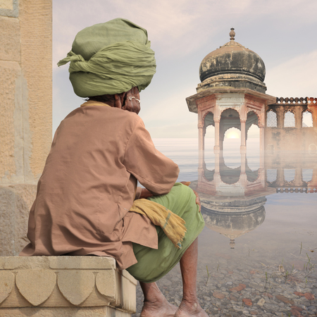 Hindu man with big turban meditating near Ganges.の写真素材