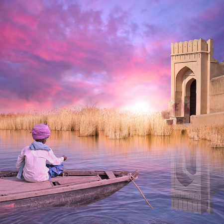 Indian fisherman on his boat during the sunrise.の写真素材