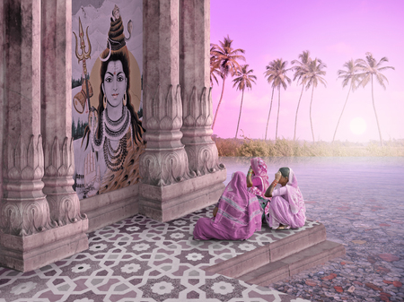 Indian women in a hindu temple during the sunrise.の写真素材