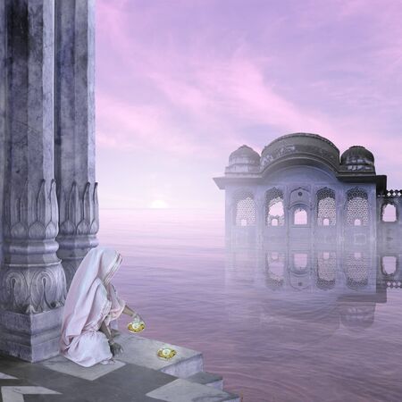Indian woman with candles in a blue sunrise.の写真素材