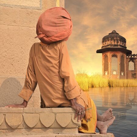 Holy man on a wall near Ganges river in the sunset.の写真素材
