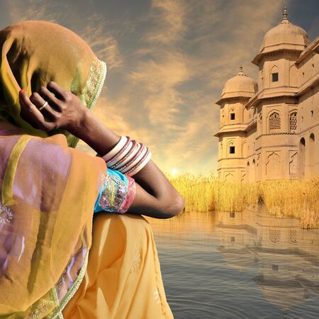 Woman near traditional indian architecture in the sunset.の写真素材