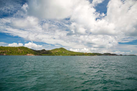 Aquamarine water, view on sunny islands with background sky with white cloudsの写真素材