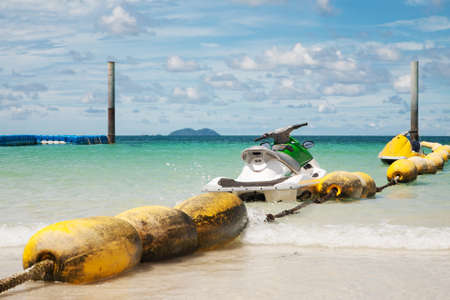 View a perfect azure beach in Pattaya Thailand, water bike near yellow pontoon, white sand and...