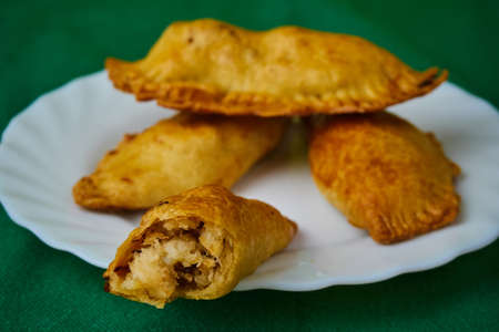 Mixed Spanish Empanadillas or spanish small pasties making a crab on a green background and a dishの写真素材