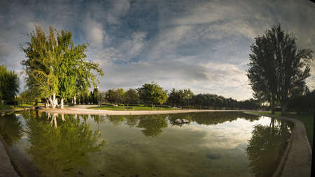park pond sunset reflections trees zaragoza parque la granjaの写真素材