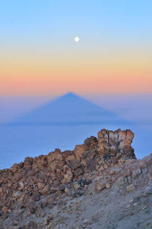 Landscape with stones, shadow of  Teide and moon in sunrise light. Tenerife, Canary islands, Spainの写真素材
