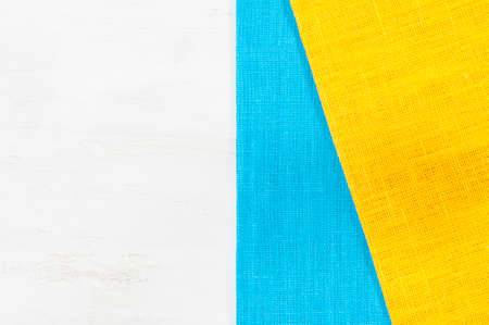 Blue and yellow napkins on white wooden table