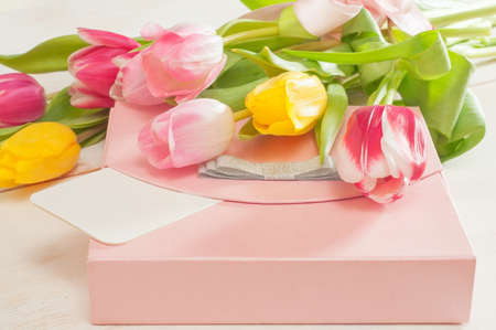 Bouquet of tulips,  gift box and blank greeting card on the wooden backgroundの写真素材