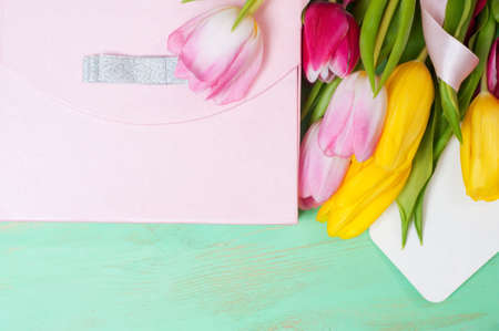 Bouquet of tulips,  gift box and blank greeting card on the wooden backgroundの写真素材