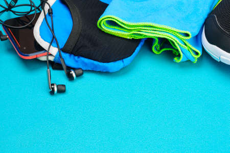 Headphones, sport bag, towel and black running shoes on the sport mat