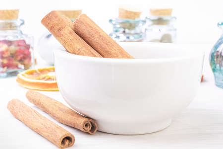 Cinnamon sticks in the pounder on white wooden table. Food foto