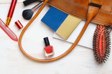 Woman's bag and it's content - nail file, polish, hair brush, book, notebook, perfume, mascaraの写真素材