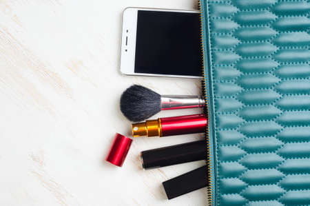 Woman's bag and it's content - lipstick, mascara, smartphone, perfume in travel applicatorの写真素材