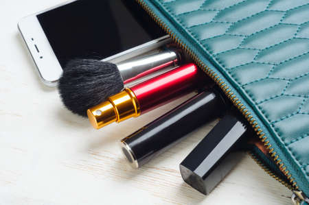 Woman's bag and it's content - lipstick, mascara, smartphone, perfume in travel applicatorの写真素材