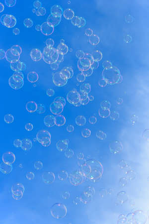 Soap bubbles against blurred blue sky backgroundの写真素材