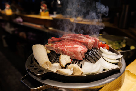 Korean barbecue, raw meets on a grill with vegetables and sides visible. Bbq.の写真素材