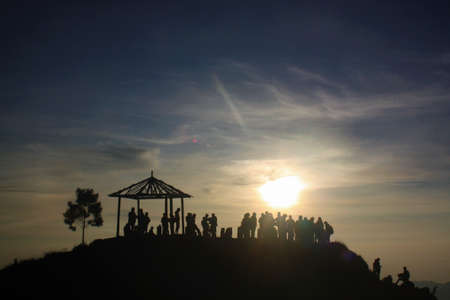 People on hills in the morning looking at a beautiful sunriseの写真素材