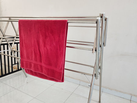 Red towel on a metal rack in a bathroom. Close up.の写真素材