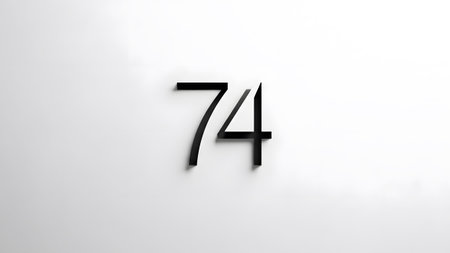 White showing modern black number seventy four with soft shadow on white surface.