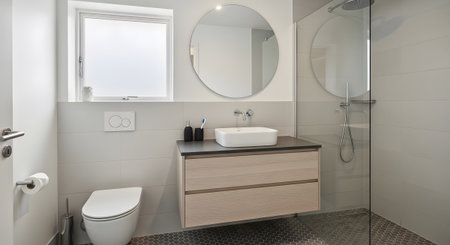 Vanity showing stylish bathroom with floating wooden vanity, square basin, and glass shower...の写真素材