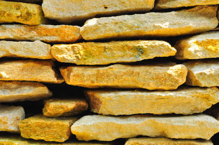 Stacks of large, thick cream and yellowish colored rock slabs の写真素材